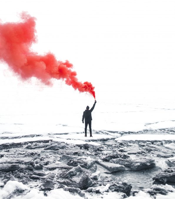 Person in black clothing holding orange smoke "How Your FAQs Can Help Customers Find You" by Deborah Beckwin