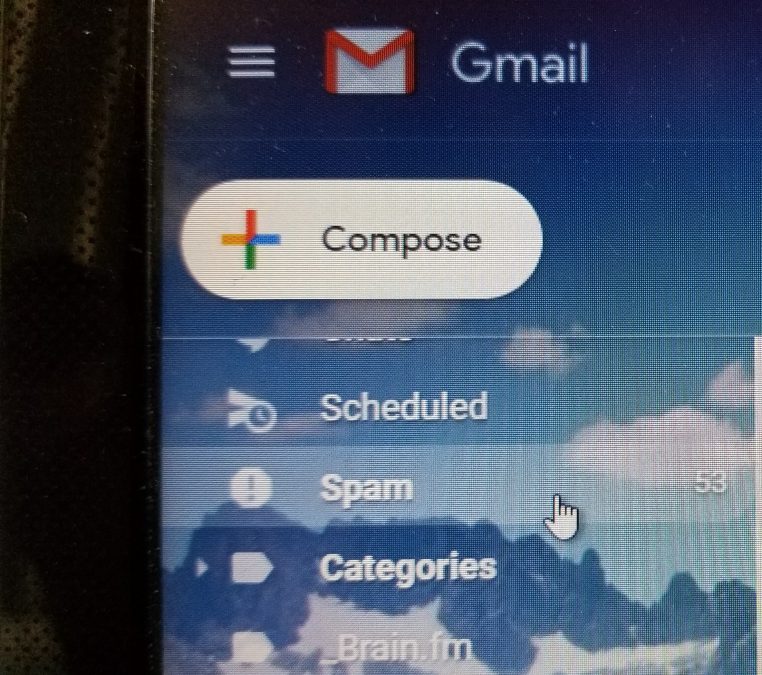 A screenshot of Gmail with the arrow hand pointing at a spam folder