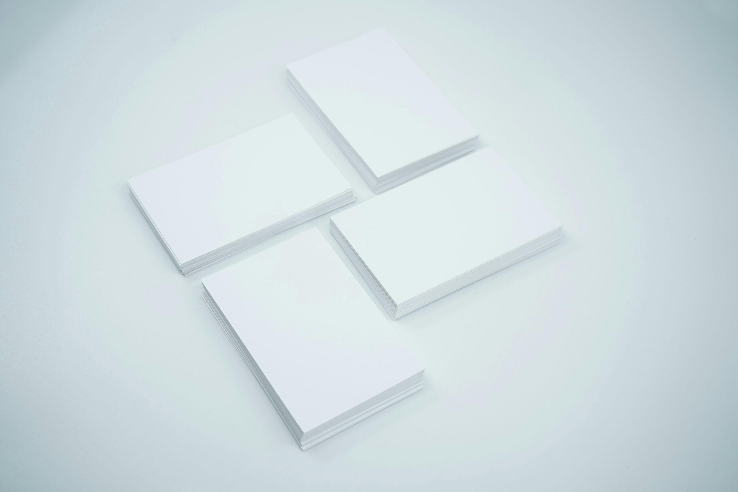 Stacks of standard size business cards aligned beautifully on a studio background.